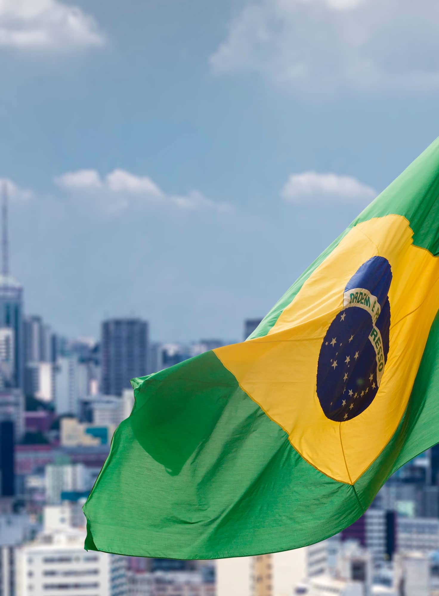 Brasilien-Flagge und im Hintergrund die Stadt Sao Paulo / Brazil flag and the city of Sao Paulo in the background.